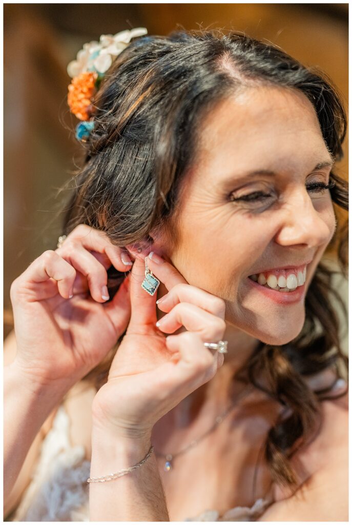 Bride putting on turquoise earrings