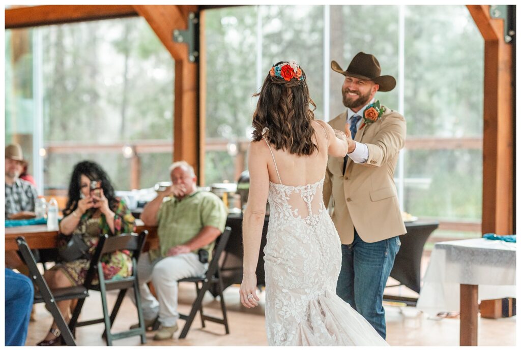 Bride and Groom's first dance with family looking on in background