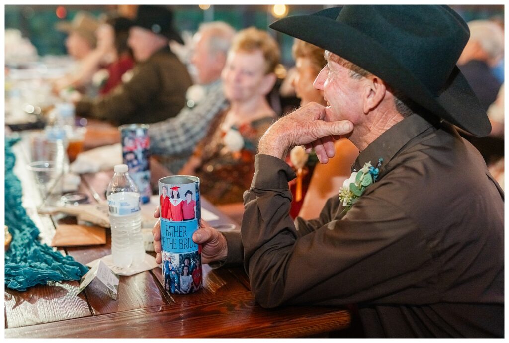 Father of bride listening to speeches while holding his custom "Father of the Bride" cup. 