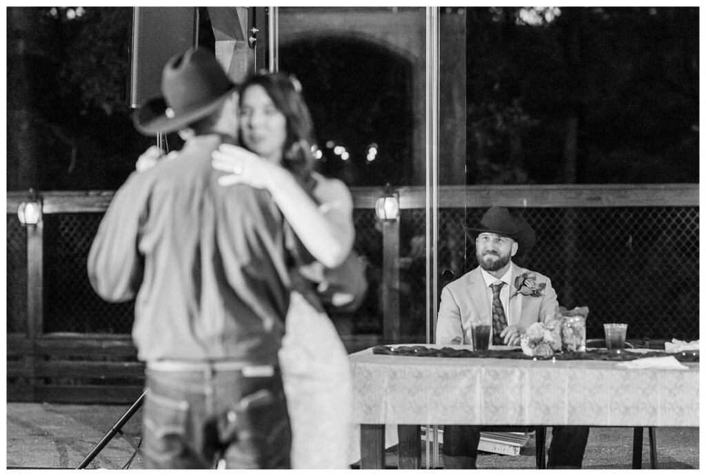 Groom watching Father Daughter dance. 