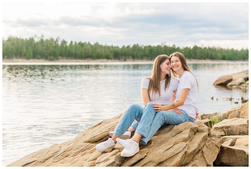 Couple sitting on rock at Willow Springs Lake for their engagement photos